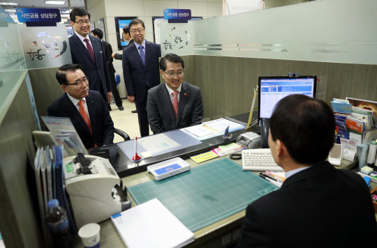 진웅섭 금융감독원장(오른쪽)이 20일 오전 서울 신한은행 불광동지점을 방문해 서민금융지원 현장을 점검하고 있다. 왼쪽은 조용병 신한은행장.  연합뉴스